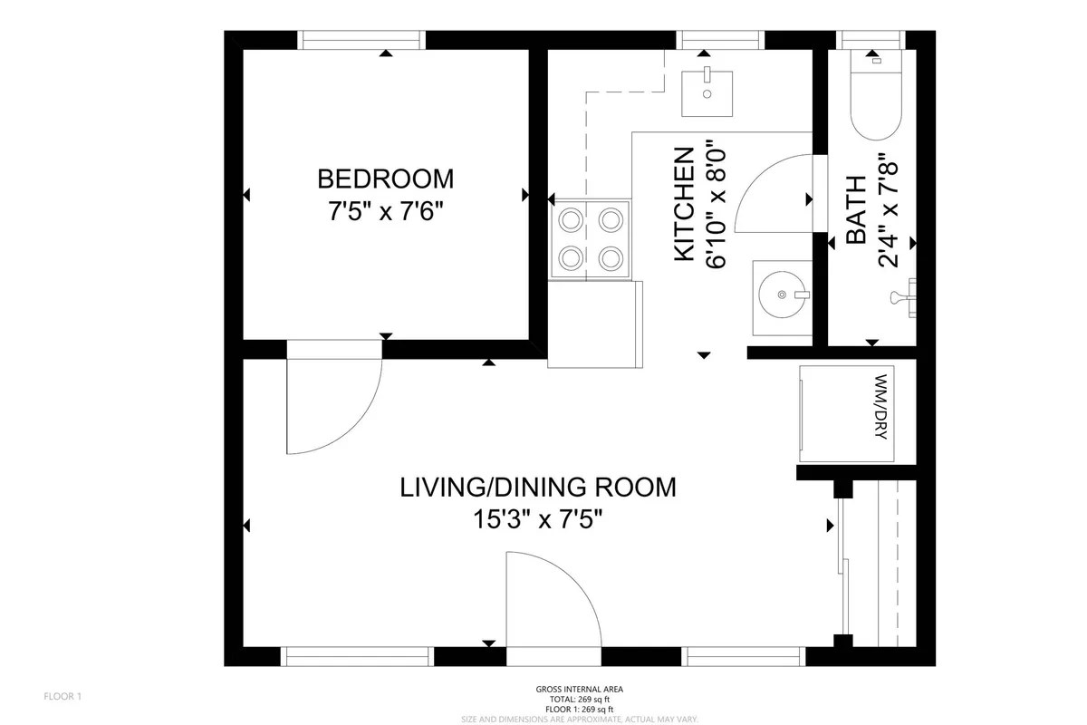 An inviting view into the open-plan living/dining area, with the bedroom visible in the background. The scene displays a cohesive, practical layout where kitchen, dining, and living spaces flow together, highlighting the modest but comfortable living arrangements. The bedroom’s presence in the background reinforces its connection to the rest of the home.